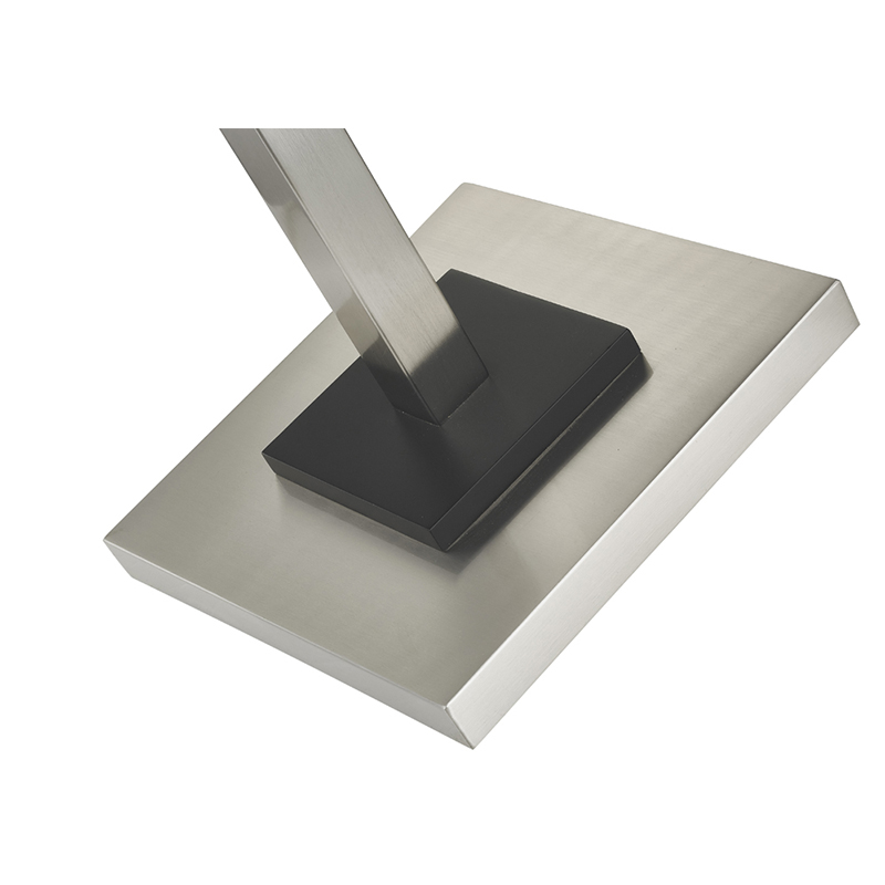 Hotelowa metalowa lampa podłogowa z szczotkowanym wykończeniemniklu i czarnym akcentem w pokoju gościnnym