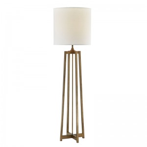 Hotelowa sofa hotelowa obok lampy podłogowej z antycznym złotym wykończeniem w pokoju gościnnym