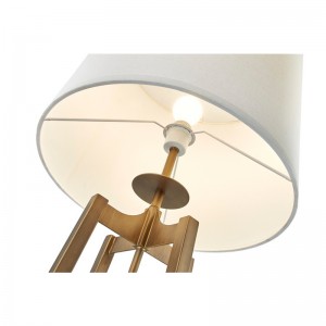 Hotelowa sofa hotelowa obok lampy podłogowej z antycznym złotym wykończeniem w pokoju gościnnym