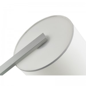 Hotelowa sofa Hiltom obok lampy podłogowej ze srebrnym wykończeniem w pokoju gościnnym