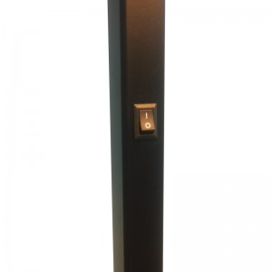 Sofa hotelowa Waterwalk obok lampy podłogowej z matowym czarnym wykończeniem w pokoju gościnnym