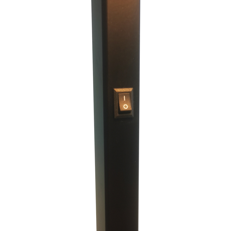 Sofa hotelowa Waterwalk obok lampy podłogowej z matowym czarnym wykończeniem w pokoju gościnnym